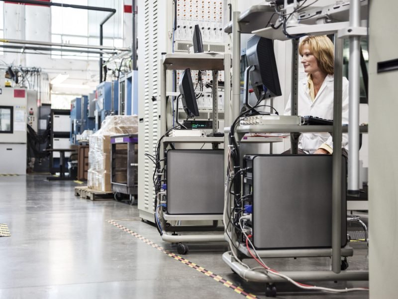 A caucaasian female techinician working over a problem in a technical research and development site.